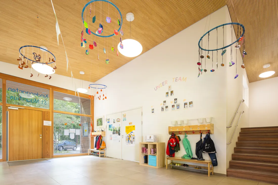 Einladender Eingangsbereich der St. Mauritius Kindertagesst&auml;tte mit Garderobe, bunten Basteleien und gro&szlig;en Fenstern